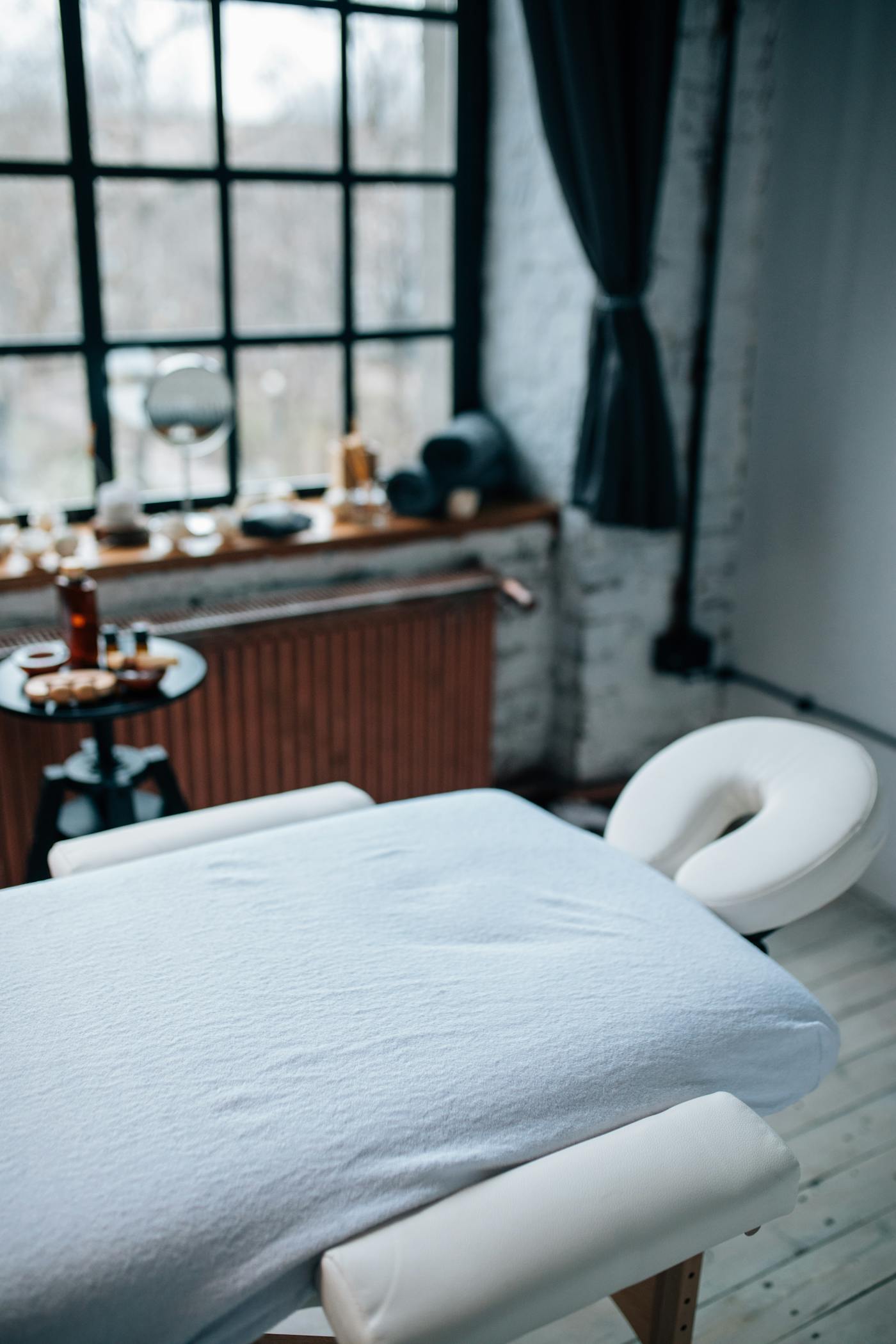 Quiet treatment room with a massage table and soft daylight